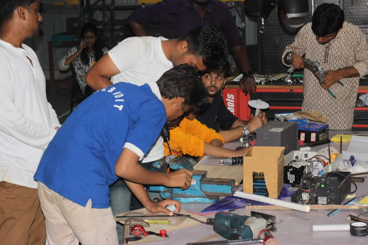 Young makers building a hardware prototype together at a workbench